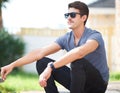 Man in sunglasses, sitting with cigarette or thinking, relax outdoor and fashion at backyard of home or house. Smoking Royalty Free Stock Photo