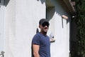 Man with sunglasses and swimsuit leaning on wall outdoors