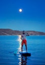 Man at Sup board against full moon at lake Royalty Free Stock Photo