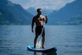 Man sup board paddle surfing. Freedom man paddle surfing. Man in lake surfing paddle. Environment and freedom lifestyle Royalty Free Stock Photo