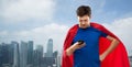 Man in superhero cape using smartphone over city Royalty Free Stock Photo