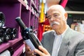 Man in supermarket comparing wine bottles Royalty Free Stock Photo