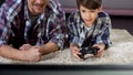 Man supporting his little son playing video game at home, family relationship Royalty Free Stock Photo