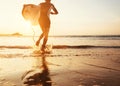 Man surfer run in ocean with surfboard in sunset light Royalty Free Stock Photo