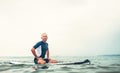 Man surfer sits on surf board in the water and waits waves