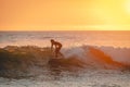 Man surfing a large wave in Northern California at sunset.