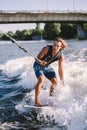 A man is surfing on a surfboard drawn by a motor boat above the wave of the boat. Weixerfer is engaged in surfing, entertainment, Royalty Free Stock Photo