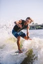 A man is surfing on a surfboard drawn by a motor boat above the wave of the boat. Weixerfer is engaged in surfing, entertainment, Royalty Free Stock Photo