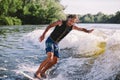 A man is surfing on a surfboard drawn by a motor boat above the wave of the boat. Weixerfer is engaged in surfing, entertainment, Royalty Free Stock Photo