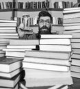 Man on surprised face holds hourglass while studying, bookshelves on background. Time flow concept. Man, scientist in Royalty Free Stock Photo