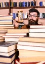 Man on surprised face holds hourglass while studying, bookshelves on background. Time flow concept. Teacher or student Royalty Free Stock Photo