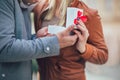 Man surprising his girlfriend with a gift, close up