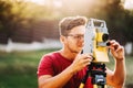 Man, Surveyor engineer working with total station on garden elevation Royalty Free Stock Photo