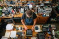 Man in Suspenders Adjusting Mechanical Calculator Among Cluttered Workshop Tools and Equipment Royalty Free Stock Photo