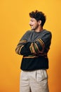 Standing man trendy male portrait happy orange fashion smile sweater background face student Royalty Free Stock Photo