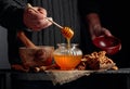 Man in a sweater prepares a breakfast of walnuts and honey