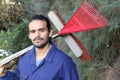 Man sweeping leaves in backyard