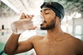 Man, swimmer and drinking water for hydration, exercise or training workout at indoor swimming pool. Active and thirsty