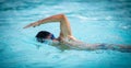 Man swimmer swimming crawl in a blue water pool Royalty Free Stock Photo