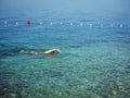 Man swimming freestyle in clear water bay in Croatia