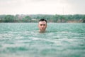 Man swimming in lake under the rain in thunderstorm Royalty Free Stock Photo