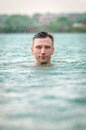 Man swimming in lake under the rain in thunderstorm Royalty Free Stock Photo
