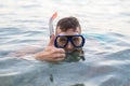 Man swimming in a mask for diving and showing a sign approx Royalty Free Stock Photo