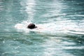 A man is swimming in the pool while it is raining. Royalty Free Stock Photo