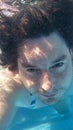 Man in swimming pool underwater. Male diving from closeup portrait front view.