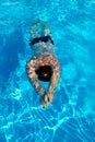 Man swims breaststroke under water in the pool