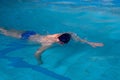 Man swims forward crawl style in swimming pool Royalty Free Stock Photo