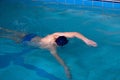 Man swims forward crawl style in swimming pool Royalty Free Stock Photo