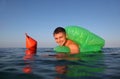 Man swims in sea on green lifeline