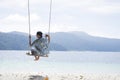 Man on a swing on a beach. Royalty Free Stock Photo