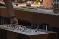 A man switches the modes of movement of miniature trains on a toy railway on the remote control, close-up.