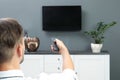 Man switching channels on plasma TV with remote control Royalty Free Stock Photo