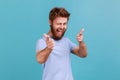 Man in T-shirt pointing fingers at camera and looking with toothy smile, believes in you, motivation Royalty Free Stock Photo