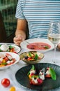 A man at a table in a restaurant tastes cold tomato soup.