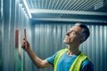 Man with tablet carefully looking at overhead lamp