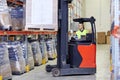 Man with tablet pc operating forklift at warehouse