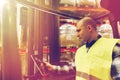 Man with tablet pc operating forklift at warehouse