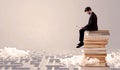 Man with tablet sitting on books Royalty Free Stock Photo