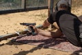 Man in tactical clothes shooting from a pistol, reloading the gun and aiming at the target in the open-door Shooting range. Royalty Free Stock Photo