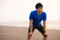 Man take break after running on beach at sunset