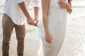 Man take care his girlfriend on beach. Boyfriend wring out the water white dress. Romantic couple on the beach