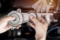 A man take off Belt Tension Pulley in old part car engine and check Replacement of spare parts in engine room Royalty Free Stock Photo