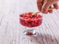 A man takes a bowl of cherry jam wooden spoon. Royalty Free Stock Photo