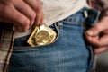 Man takes out gold-colored condom from his jeans pocket. Prevention of sexually transmitted diseases and AIDS. Sensible