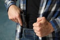 Man takes out a gun from jeans, close up
