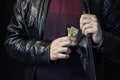 A man takes out money from a breast pocket, a black background, a black jacket Royalty Free Stock Photo